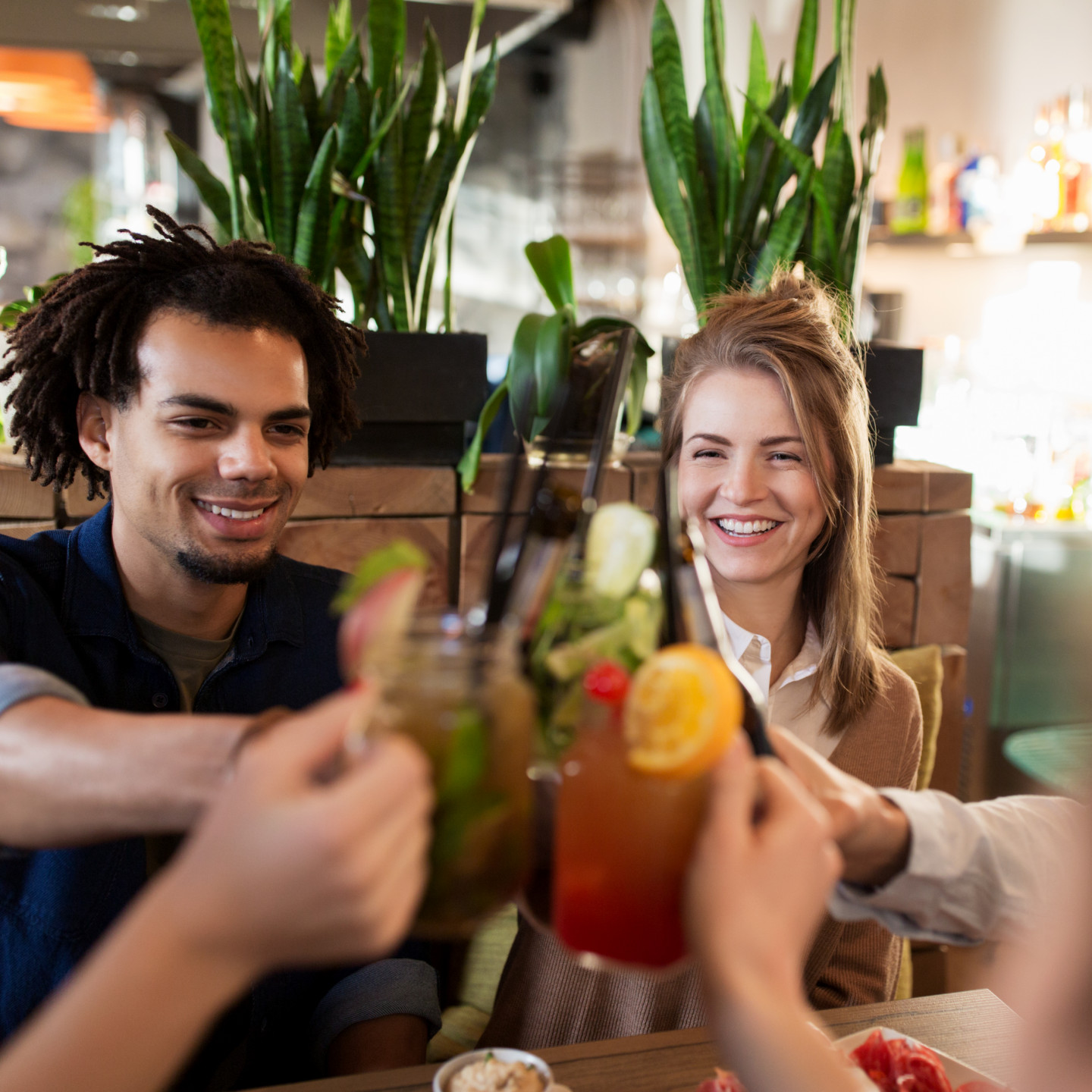 happy-friends-clinking-drinks-at-restaurant-2022-12-16-09-42-03-utc